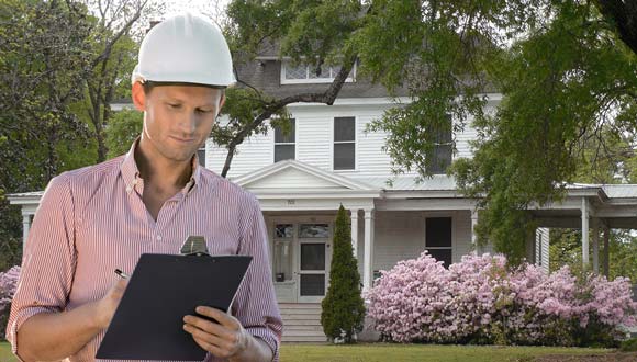 A Salt Lake City home inspector in front of a house, going over the checklist.